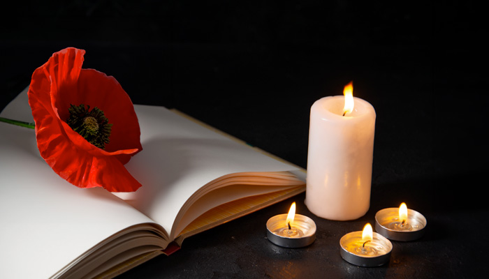 Book of remembrance with a poppy and candles