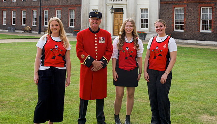 Supporters wearing Chelsea Pensioner running vests stand alongside a Chelsea Pensioner at Figure Court