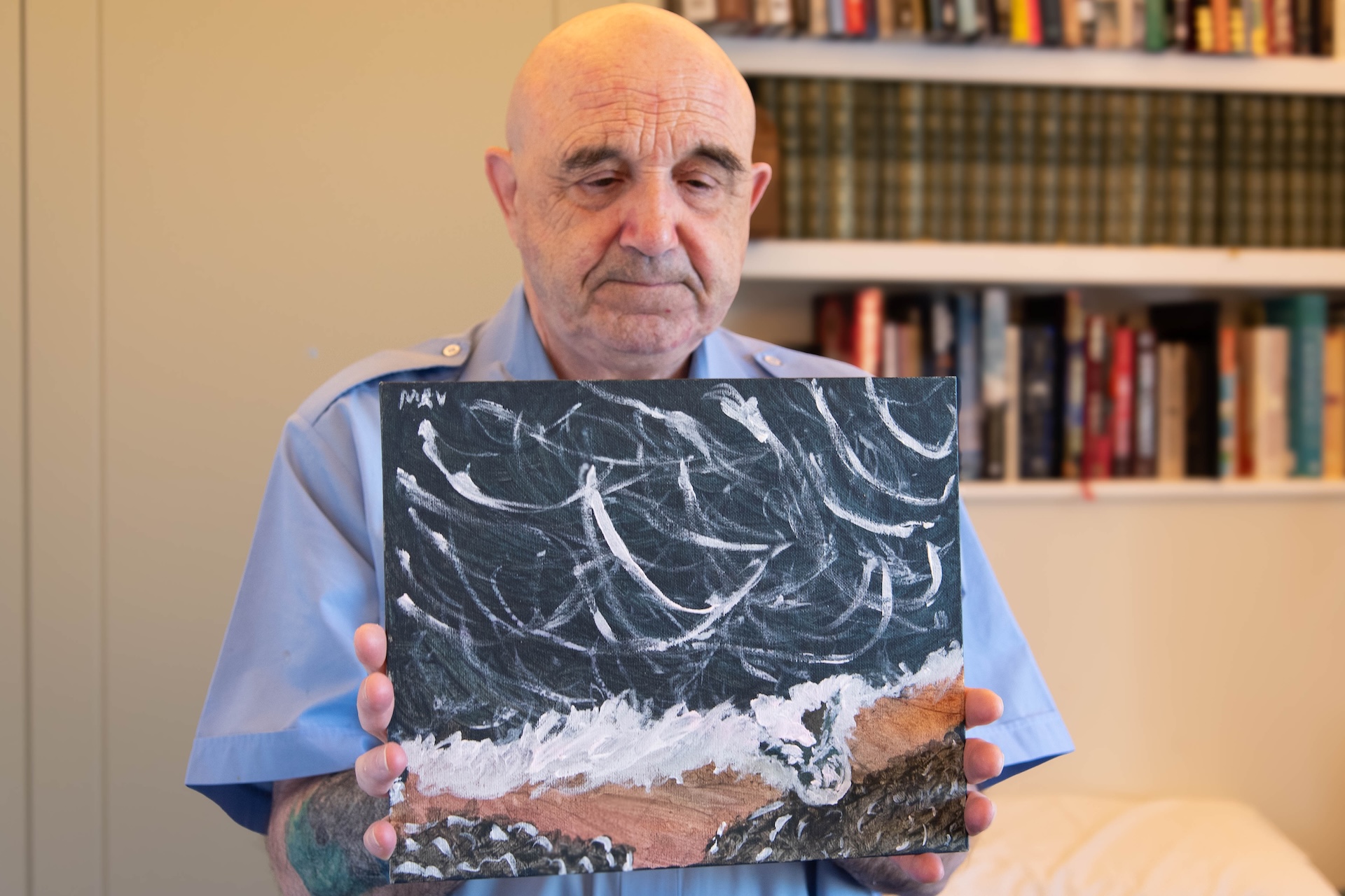 Chelsea Pensioner, Tony, holding his seascape artwork 