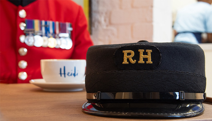 A Chelsea Pensioner Shako hat sits alongside a cup of coffee at the Cafe by Heidi Bakery