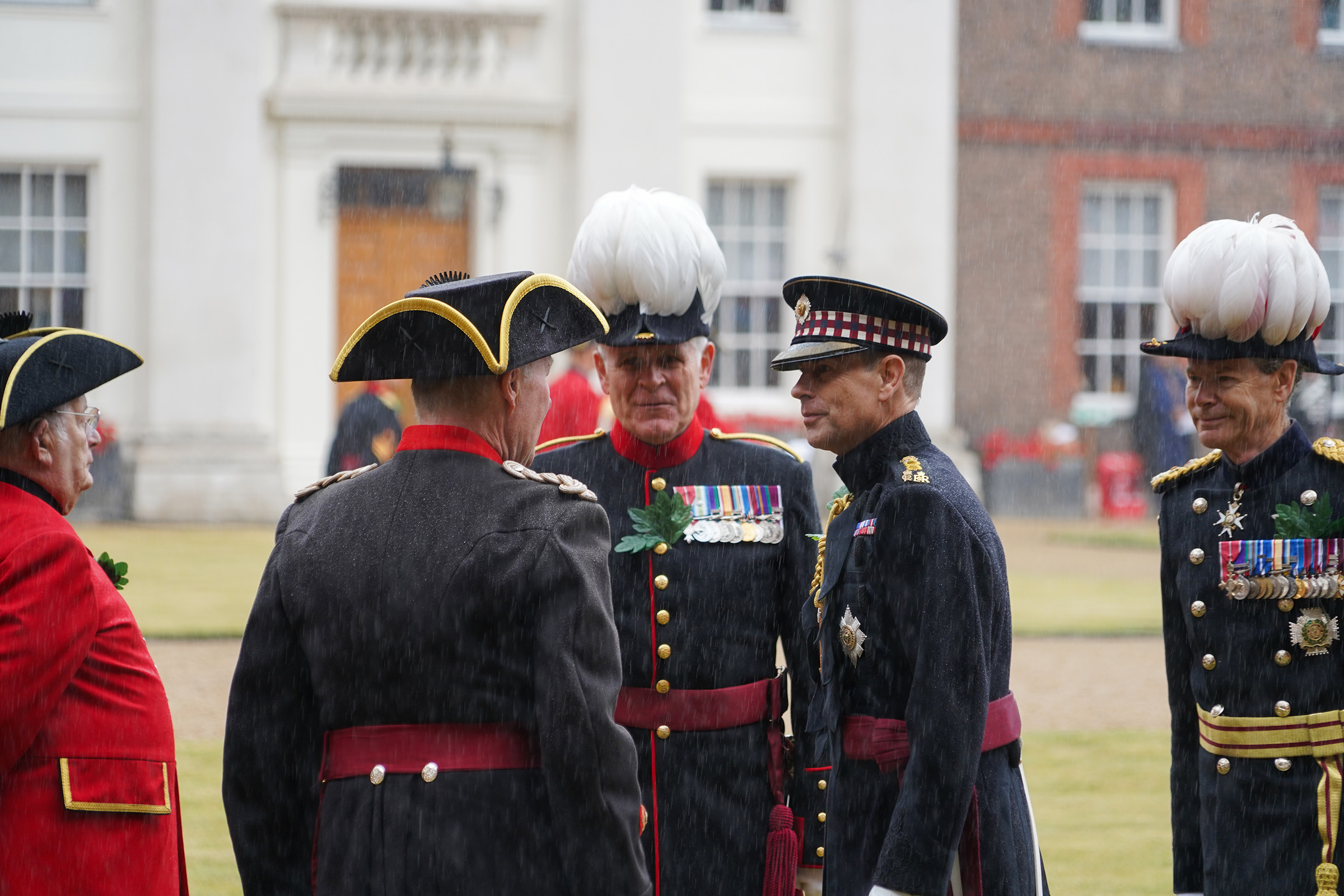 His Royal Highness The Duke of Edinburgh meets staff and Chelsea Pensioners outdoors in heavy rain at the Founder's Day 2025 parade.