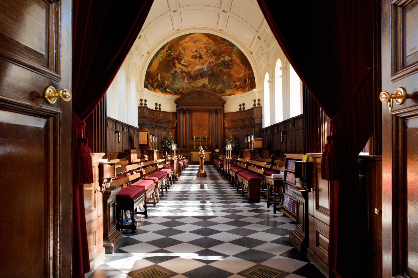 View through the Chapel doors at the Royal Hospital Chelsea, revealing the historic Wren-designed interior with chequered floor and painted apse.