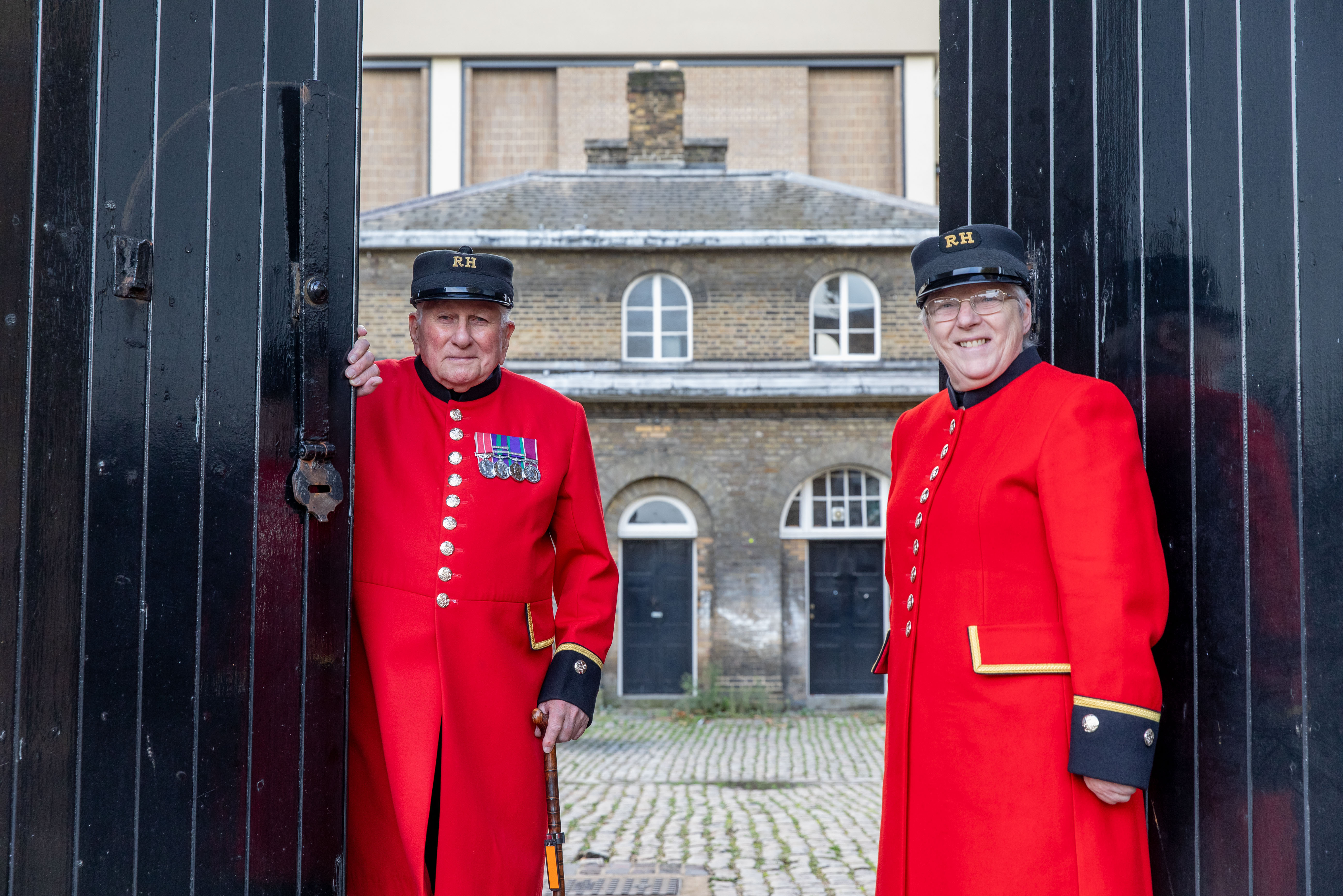 Two Chelsea Pensioners in front of the doors of Soane Stable Block