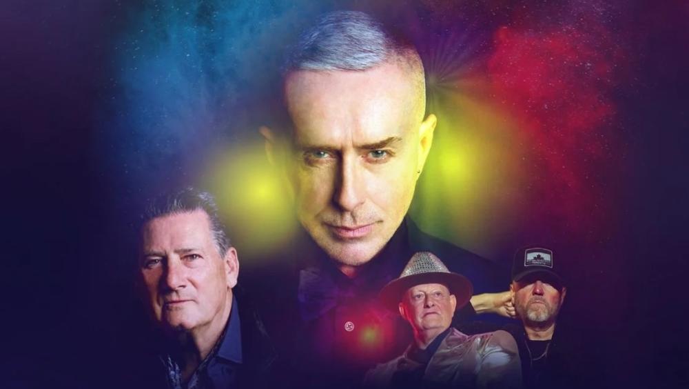 Promotional image of four musicians with a central portrait against a colourful, cosmic-style background.