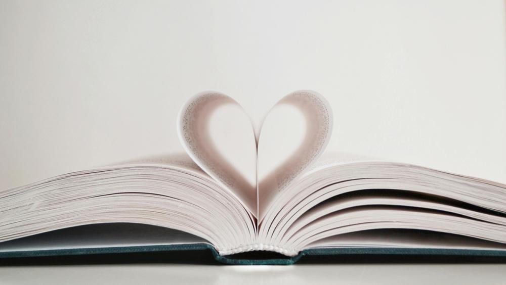 Open book with pages folded into a heart shape, symbolising love, memory and tribute.