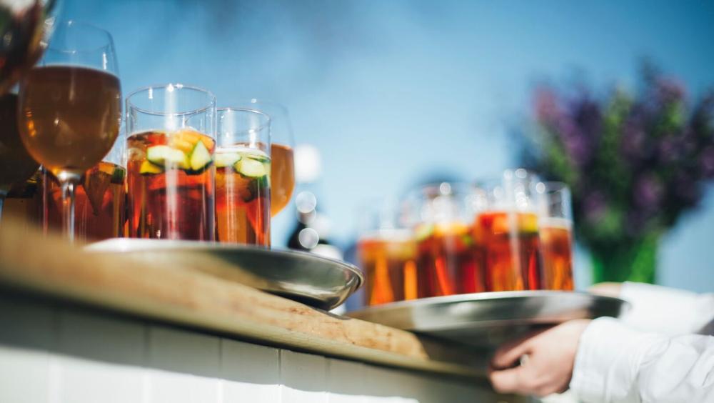 Refreshing drinks being served at an outdoor hospitality reception at the Royal Hospital Chelsea's Burton Court Pavilion.