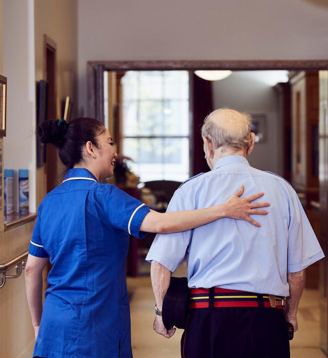 A nurse provides a comforting hand of support for a Chelsea Pensioner in the Infirmary