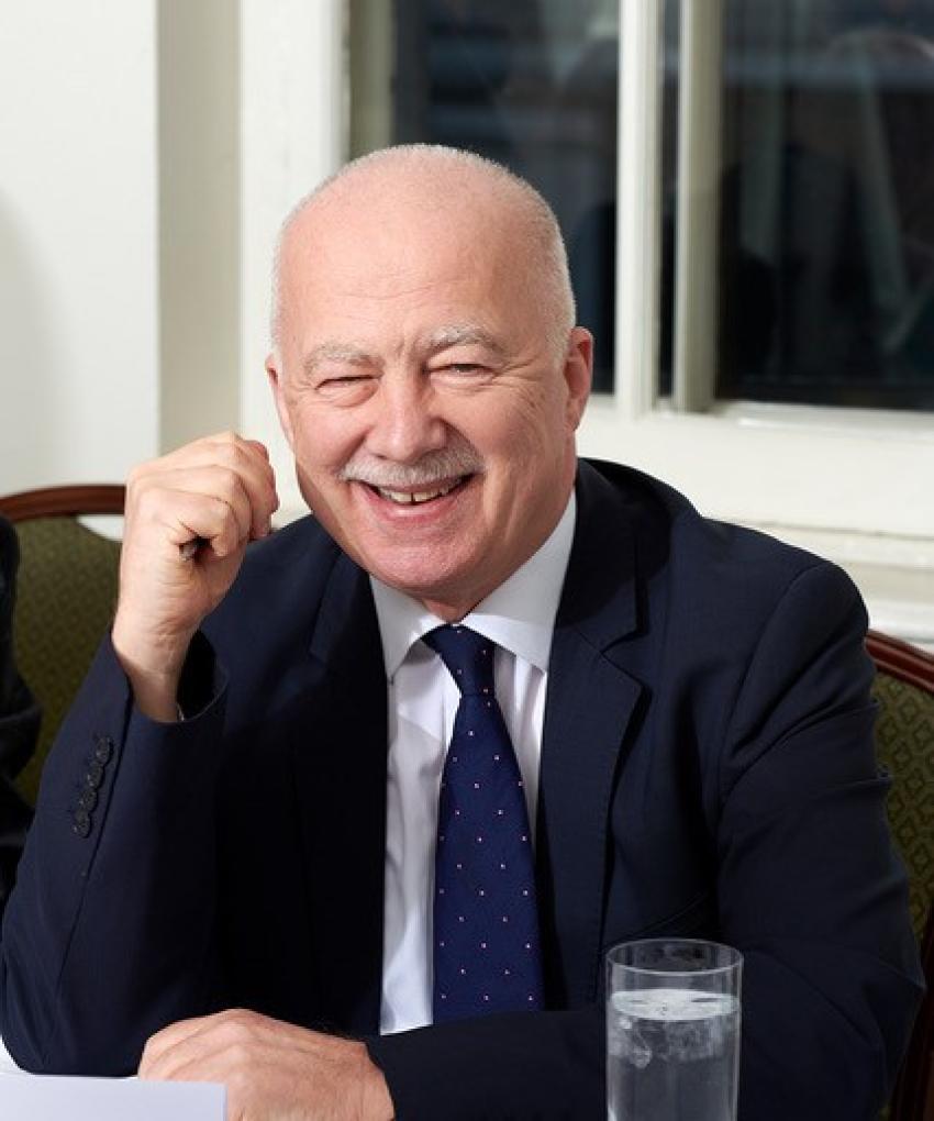 Dr Philip Mansel smiling whilst sitting at a table 