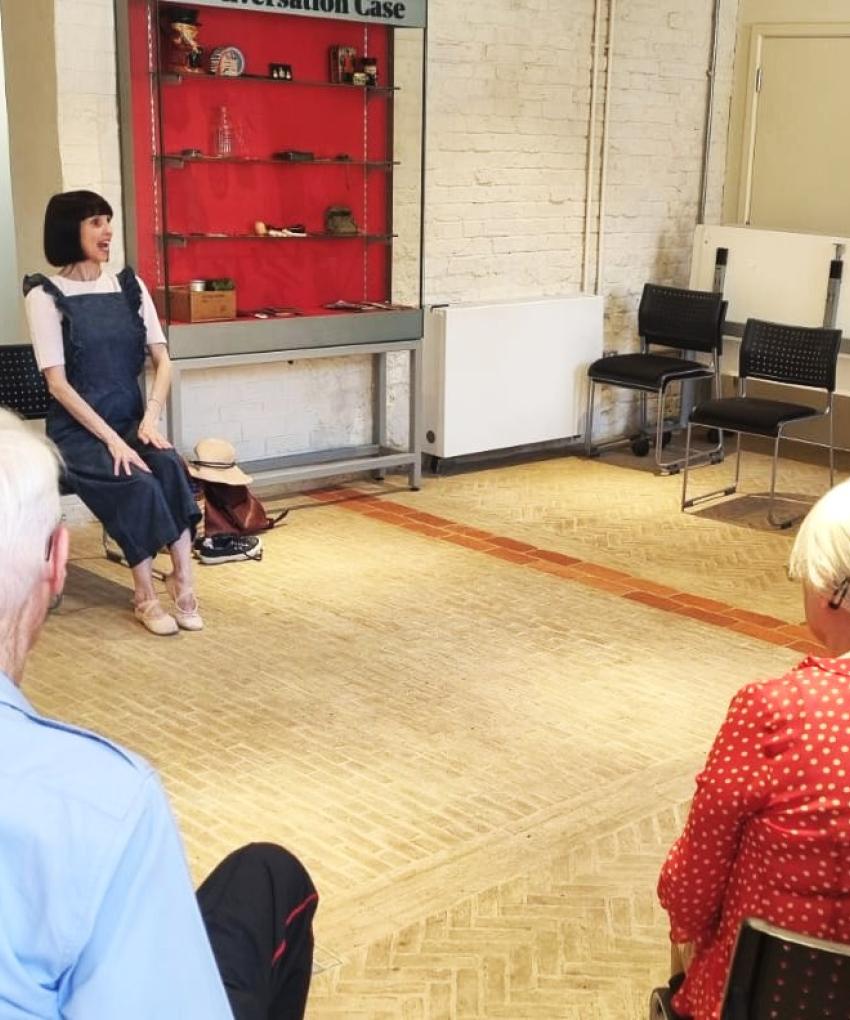 an image of a seated movement to music class featuring an instructor speaking to elderly participants