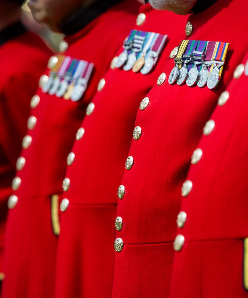 An image of the scarlet red coats of Chelsea Pensioners in a row at Royal Hospital Chelsea