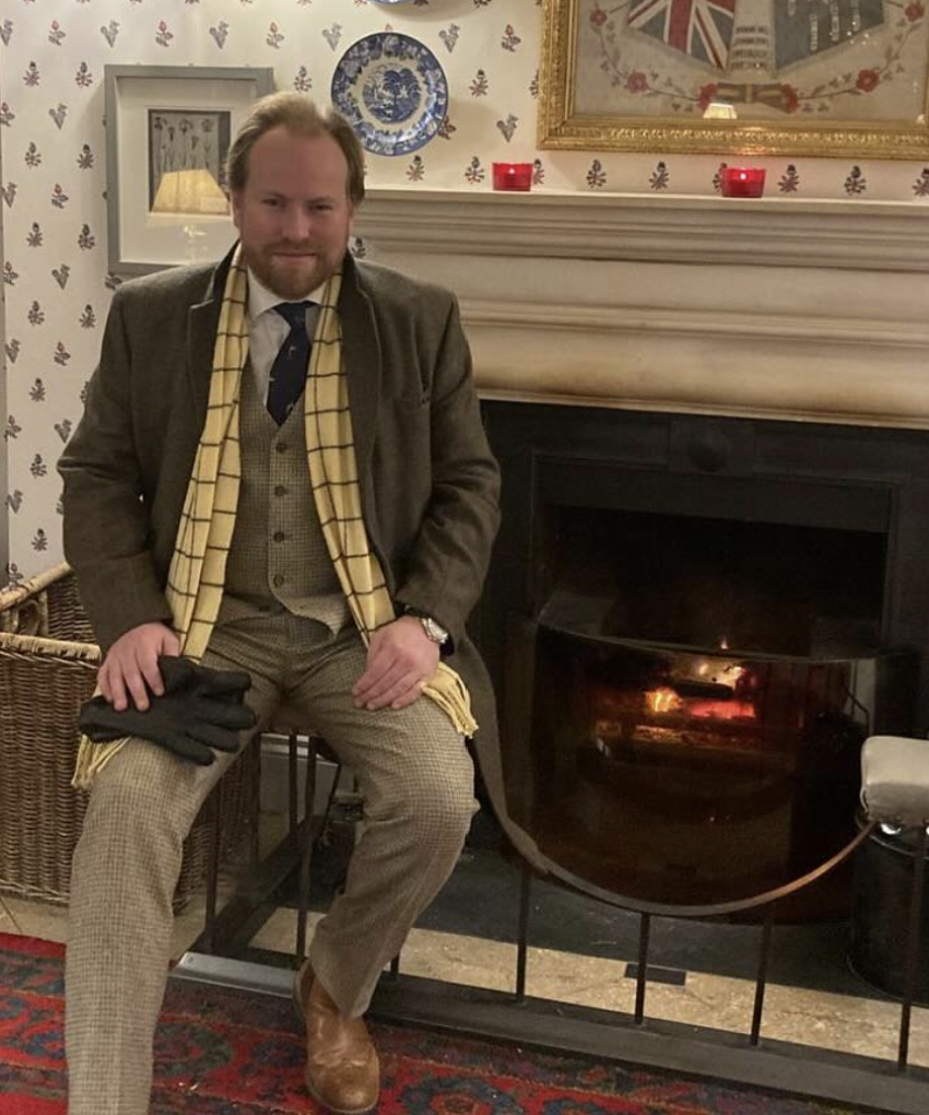 Edward Hilary Davis, the speaker at this Governor's Lecture Series event at Royal Hospital Chelsea, sitting on a chair in front of a fireplace