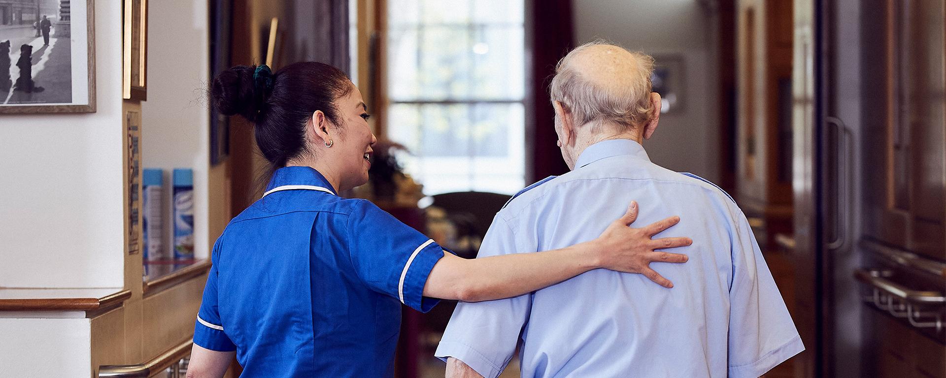 A nurse provides a comforting hand of support for a Chelsea Pensioner in the Infirmary