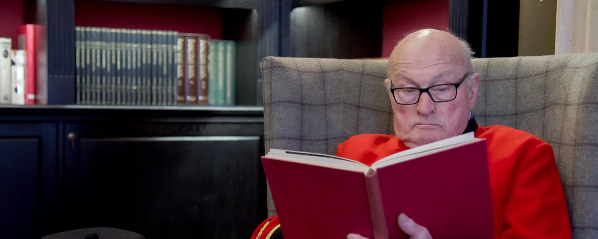 Chelsea Pensioner Colin Thackery and winner of Britain's Got Talen sit in the library reading.