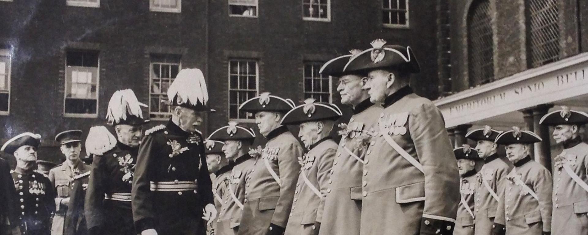 Black & white historic photo of the Chelsea Pensioners being reviewed during Founder's Day on Figure Court - Royal Hospital Chelsea