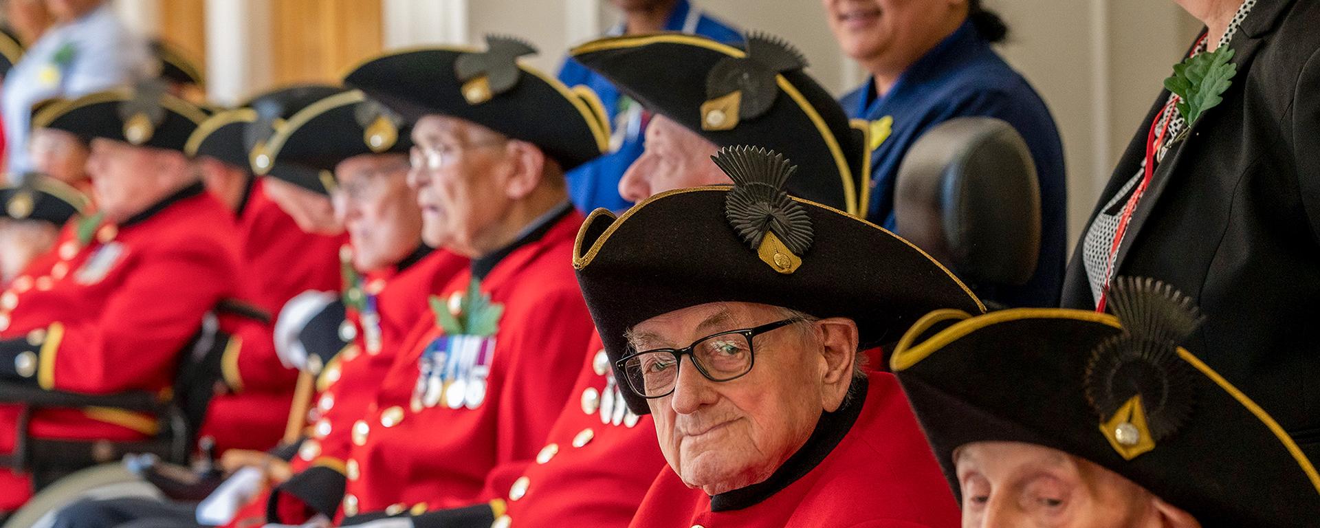 Chelsea Pensioners sitting in wheelchairs accompanied by nurses and carers from The Royal Hospital Chelsea