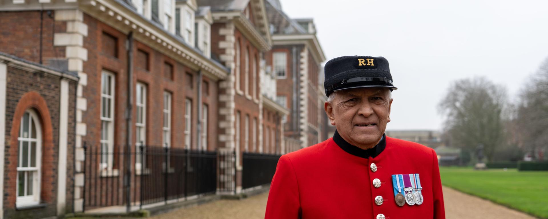 Man dressed in red uniform stood outside