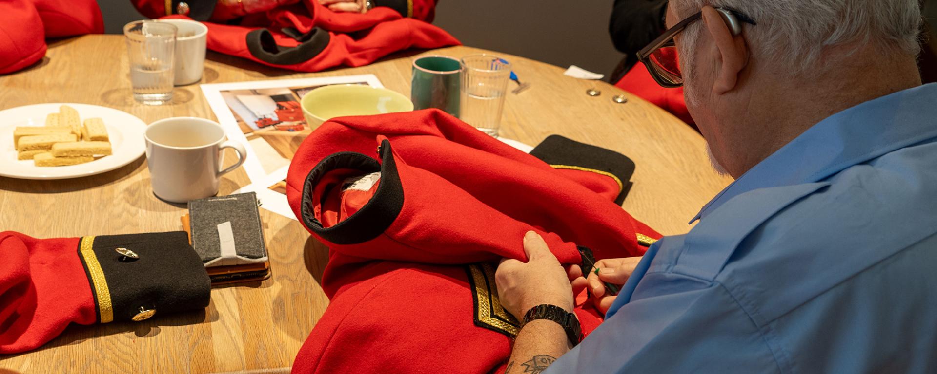 A Chelsea Pensioner unpicks an iconic decommissioned scarlet jacket for repurposing into luxury hand-made goods.