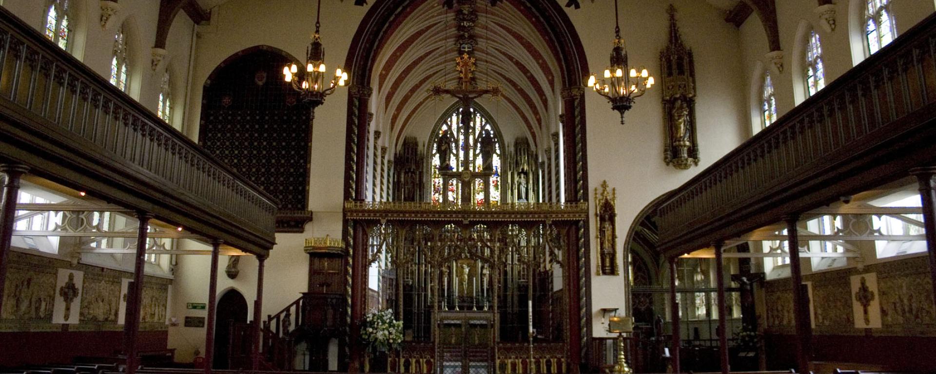 Internal photo of St Pauls in Knightsbridge, with auditorium style seating along the middle, and balcony seating either side. A large pulpit framed by an archway sits at the far end.