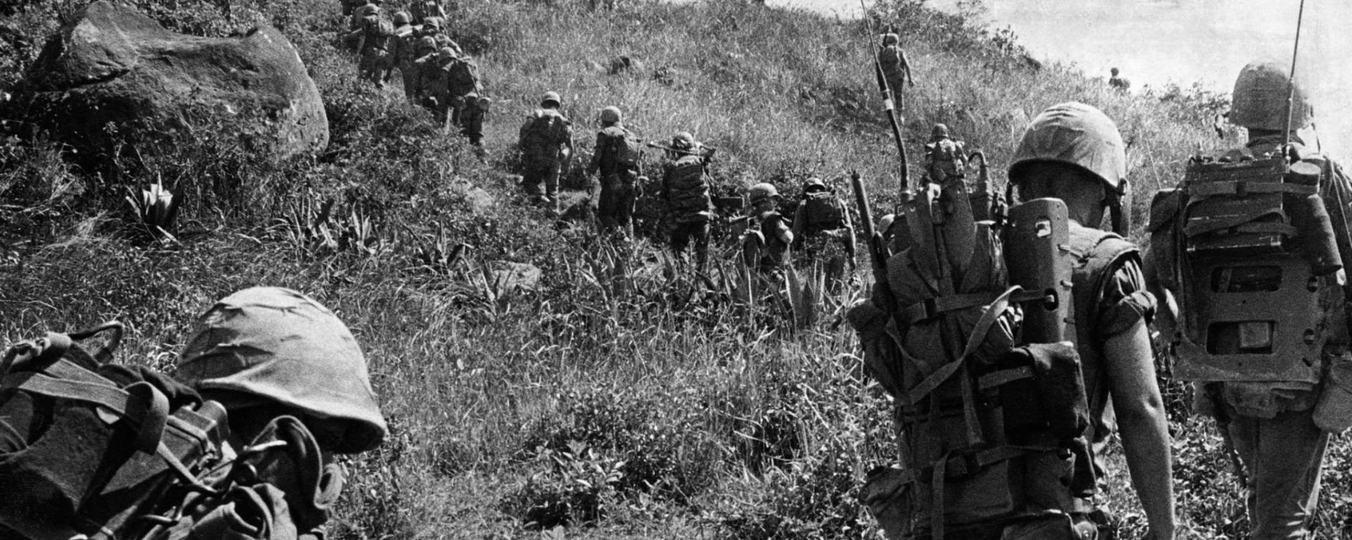 Library archive image of troops at the Vietnam War overlooking a field - black and white photograph