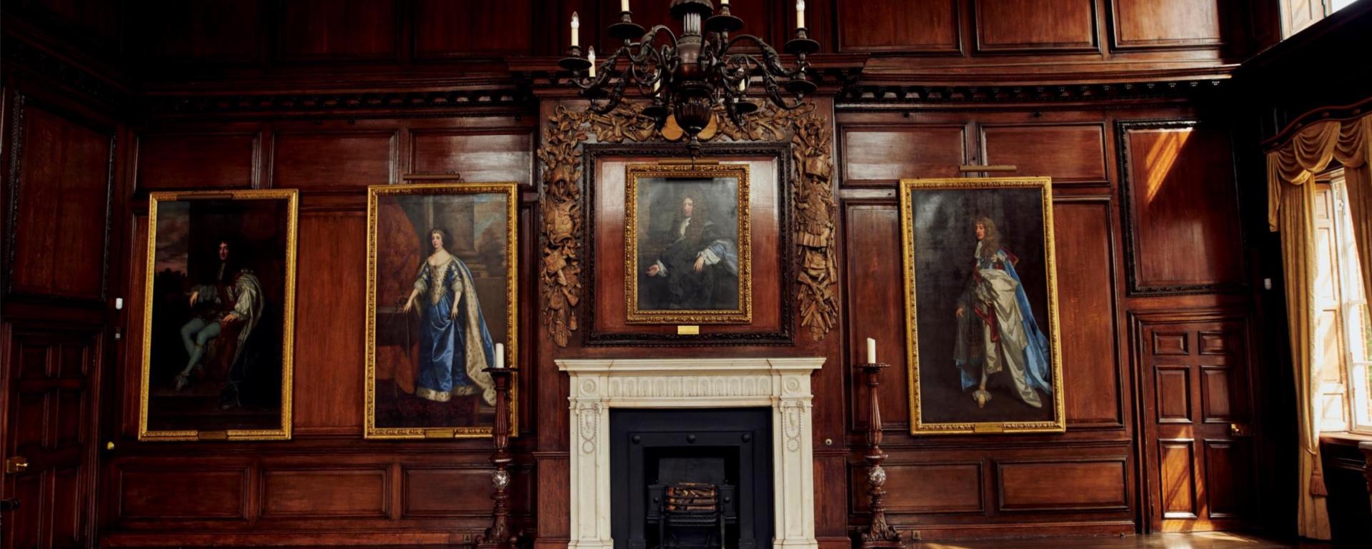 The State Apartments at the Royal Hospital Chelsea, featuring historic portraits, a decorative fireplace and original wood panelling.