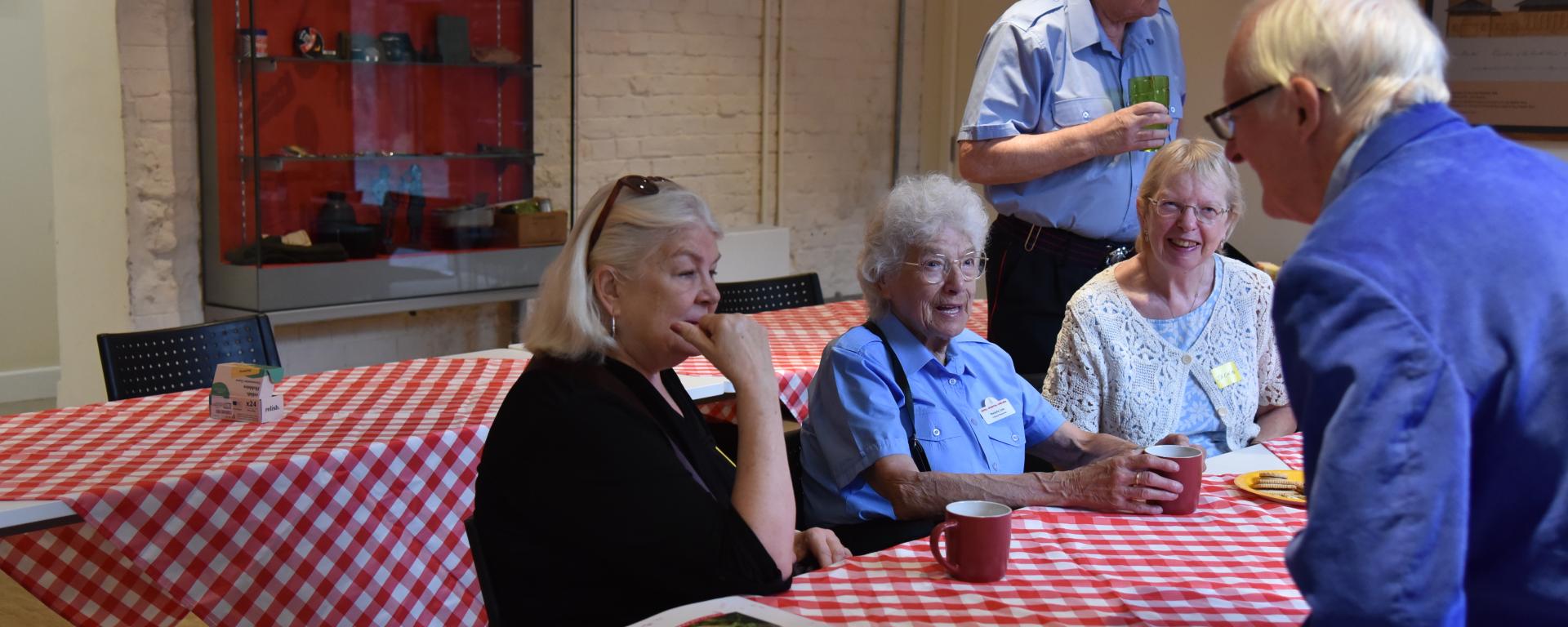An image of a few Chelsea Pensioners talking to each other and members of the public at a Royal Hospital Chelsea Community Coffee Morning