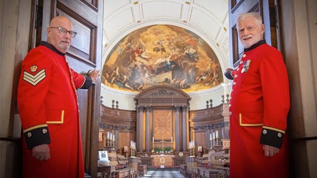 Chelsea Pensioners holding open the doors of the Wren Chapel to welcoming visitors