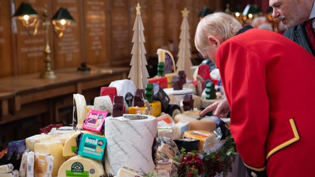 Chelsea Pensioner looking at cheeses on a table at the Ceremony of Christmas Cheeses