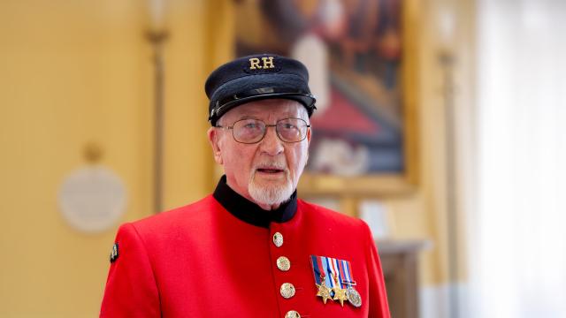 VE Day veteran, Brian Howarth stands in his iconic scarlet coat and shako hat