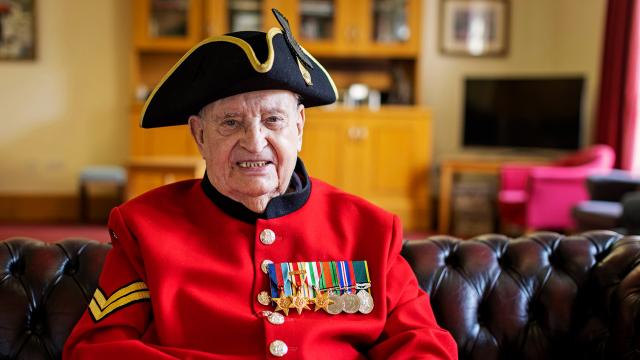 John G Morris, Chelsea Pensioner sits in the MTI wearing iconic scarlet uniform and tricorn hat.