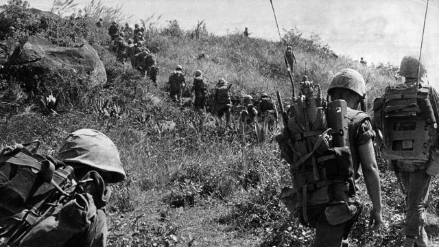 Library archive image of troops at the Vietnam War overlooking a field - black and white photograph