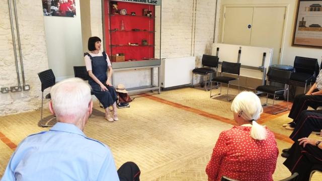 an image of a seated movement to music class featuring an instructor speaking to elderly participants