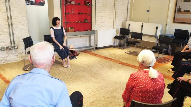 an image of a seated movement to music class featuring an instructor speaking to elderly participants
