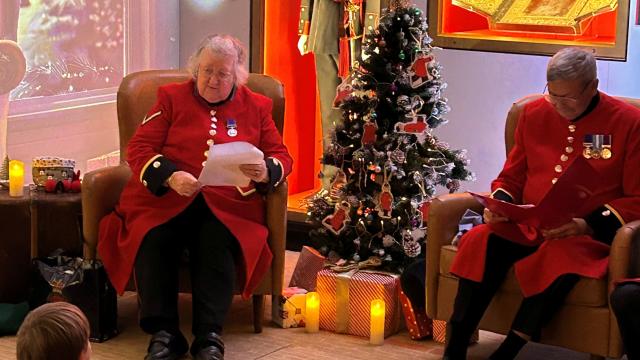 two chelsea pensioners reading christmas stories to children